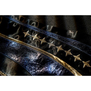 Honkai Star Rail Khaslana cosplay coat detail shows star accents set along blue-edged black fabric