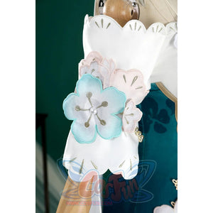 Honkai: Star Rail Ruan Mei cosplay costume wrist flower cuff detail layers pale petals and gold beads over teal fabric.