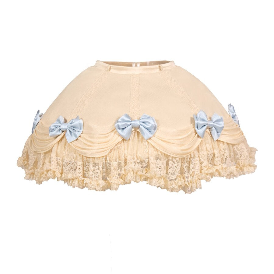 Flat lay of a cream lace cake skirt with blue bows and layered ruffle trim