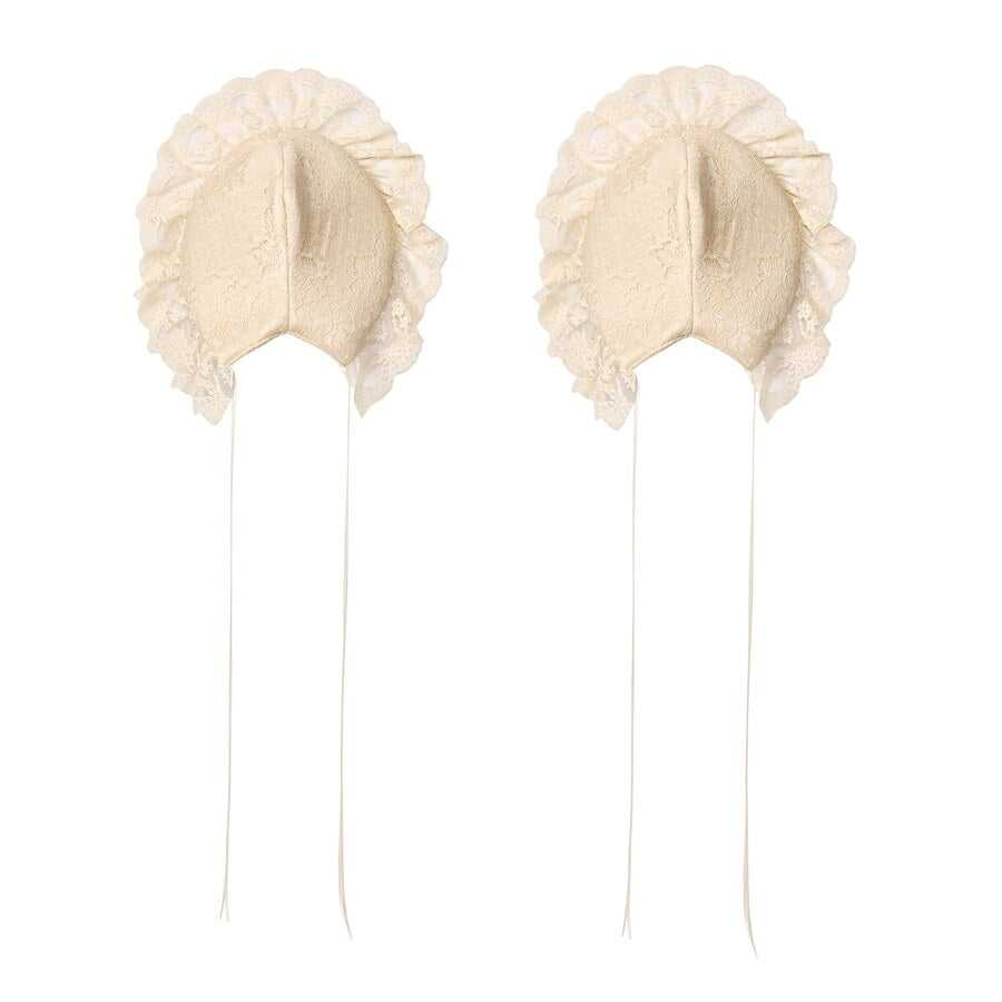 Flat lay of cream lace hip pads with ruffled edges and long tie straps