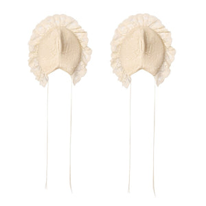 Flat lay of cream lace hip pads with ruffled edges and long tie straps
