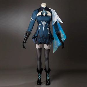 Genshin Impact Lumine cosplay costume shows a teal outfit with black gloves and patterned socks beneath a pale drape.