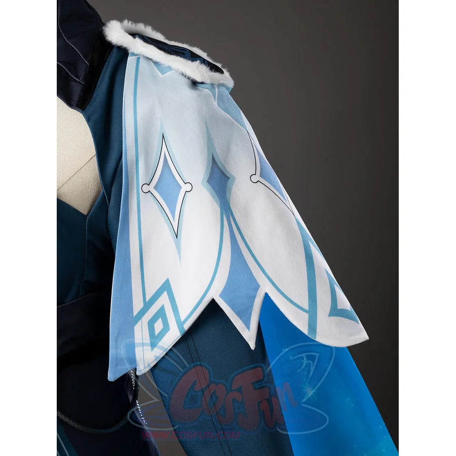 Lumine cosplay shoulder drape detail layers pale fabric and turquoise edging around geometric motifs.