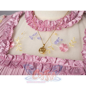 Melanie Martinez K-12 Cry Baby cosplay necklace detail rests over floral mesh and pink ruffle trim.