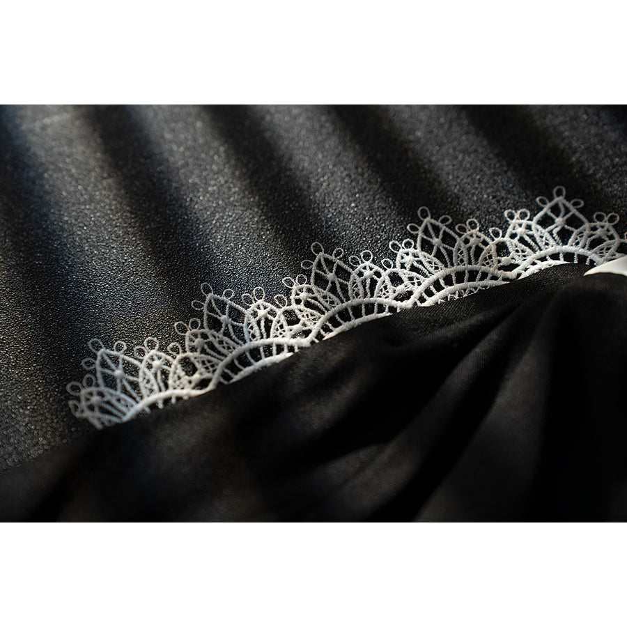 Genshin Impact Noelle cosplay black lace fabric swatch shows delicate floral edging over dark cloth.