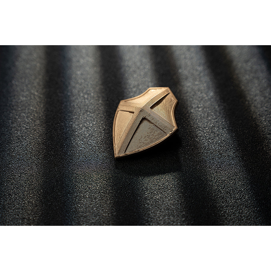 Genshin Impact Noelle cosplay gold-tone shield accessory shows an angular leaf cutout design.