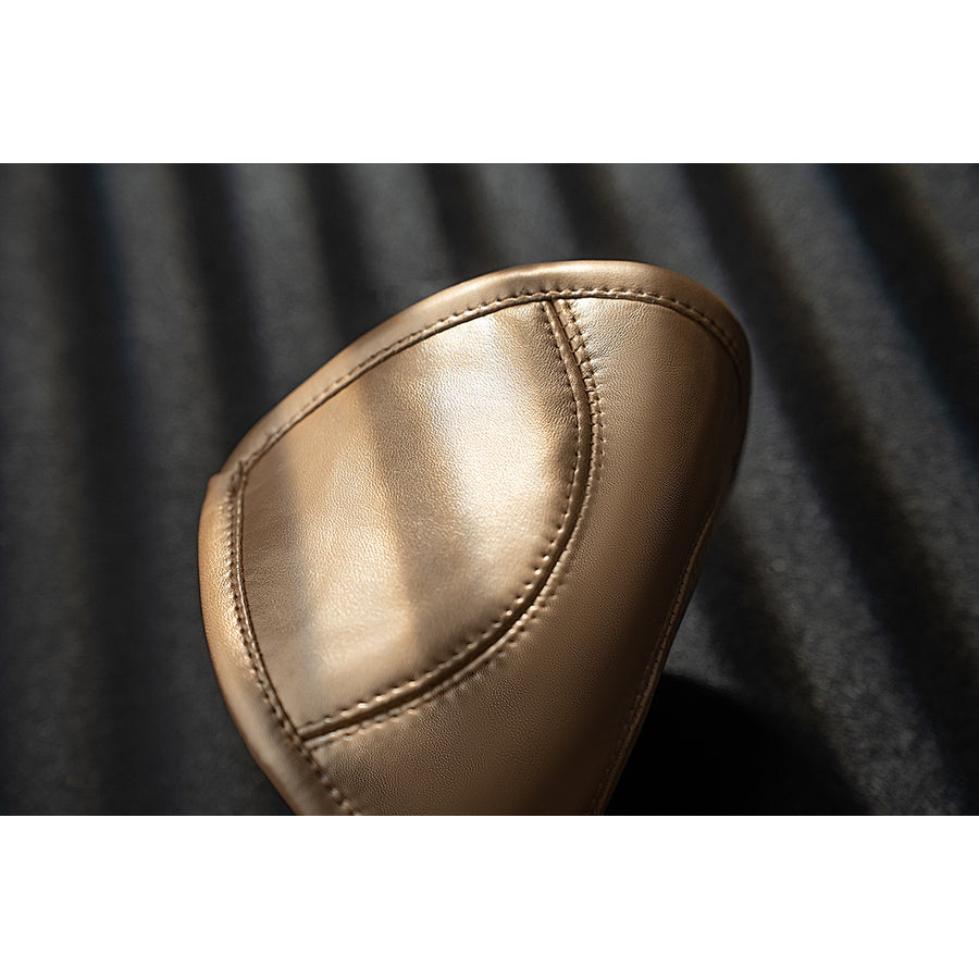 Genshin Impact Noelle cosplay knee pad close-up highlights a white oval panel bordered by gold trim.