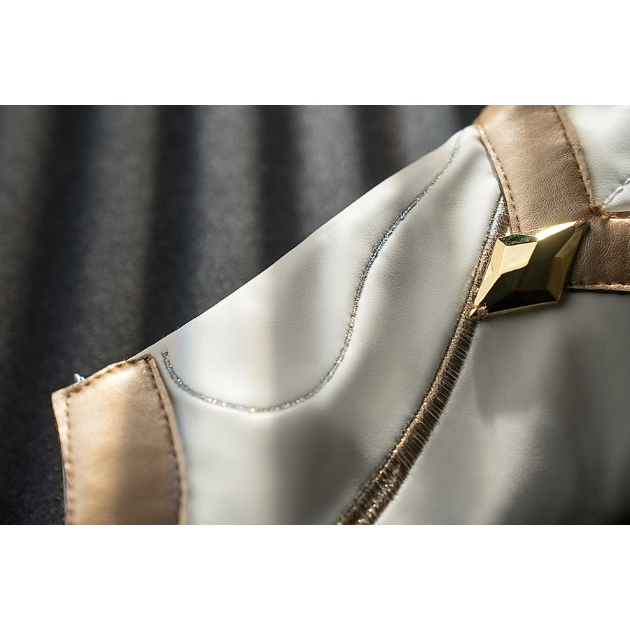 Genshin Impact Noelle cosplay leg guard buckle detail sets gold trim around white armor panels.