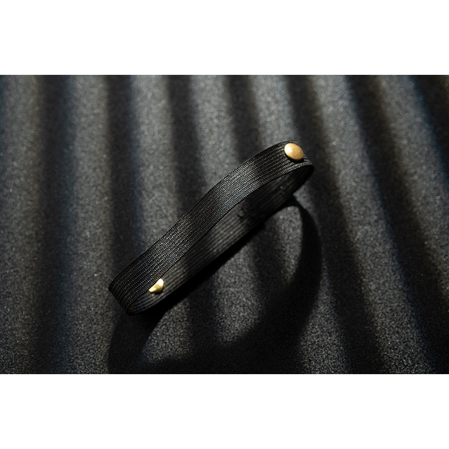 Genshin Impact Noelle cosplay thigh strap detail uses black faux leather finished with gold buttons.
