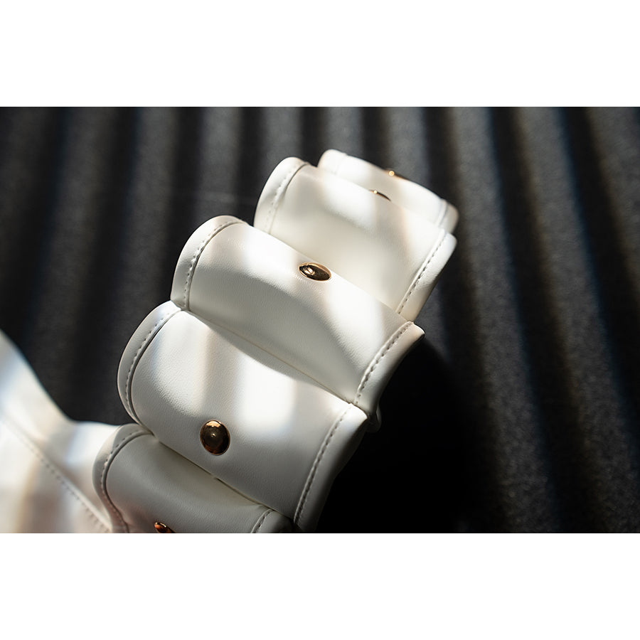Genshin Impact Noelle cosplay wrist guard detail shows white armor plates finished with gold buttons.