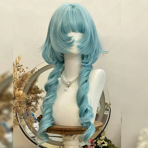 Peacock teal blue long wavy lolita wig with soft bangs displayed on a white mannequin bust, featuring loose curls and styled with dried floral decor in the background