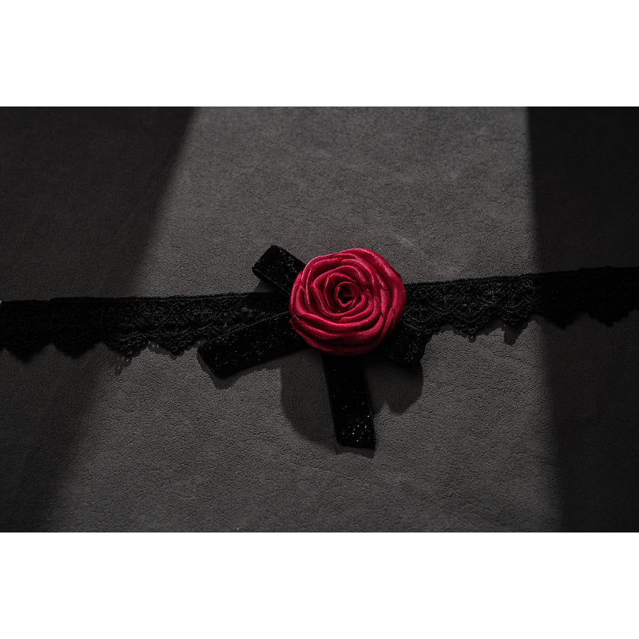 Wuthering Waves Phrolova cosplay rose collar accessory flat lay shows a red flower on black lace trim.