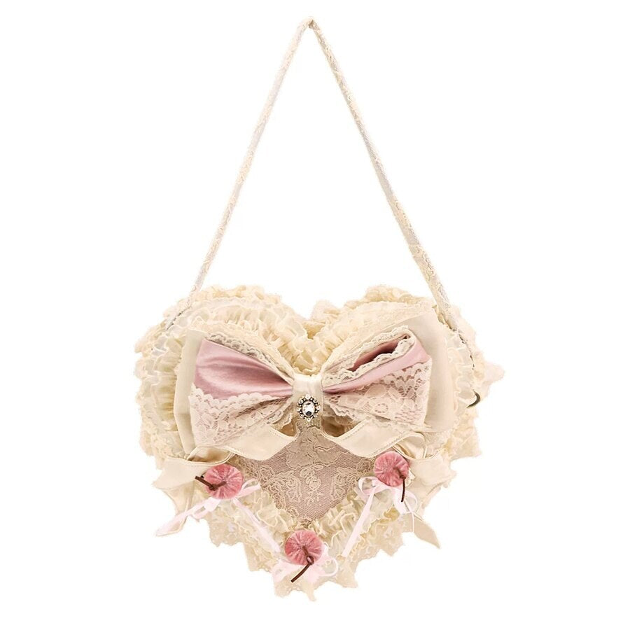 Pink heart handbag flat lay on a white background with lace ruffles, satin bow, and cherry accents