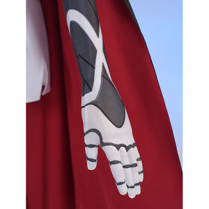 Sapphire cosplay costume layers patterned fabric on the fitted sleeve and matching fabric glove against a red capelet.