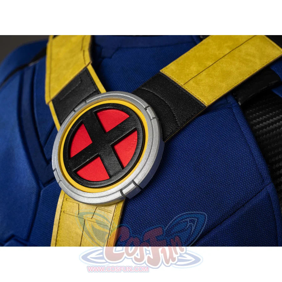 Scott Summers cosplay chest emblem close-up sets a red X crest inside round trim over yellow harness straps.