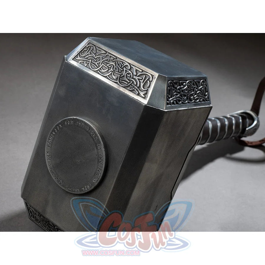 Thor cosplay hammer captures engraved knotwork patterns on the metallic head with a circular inscription on the side.