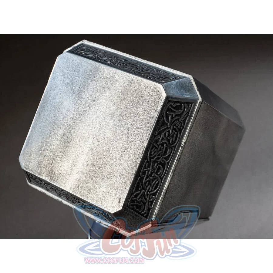 Thor cosplay hammer head gathers brushed metal surfaces that frame dark ornate knotwork patterns along the beveled edges.
