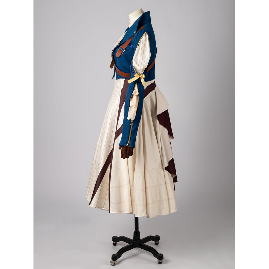 Violet Evergarden cosplay costume frames a blue jacket with brown straps layered over a patterned cream pleated dress.