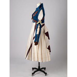 Violet Evergarden cosplay costume frames a blue jacket with brown straps layered over a patterned cream pleated dress.