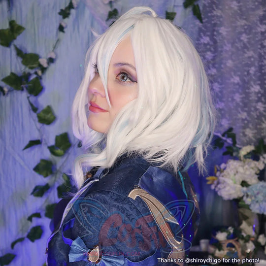 Genshin Impact Furina cosplay wig traces light blue highlights through wavy white hair beside a gold-trim blue jacket.