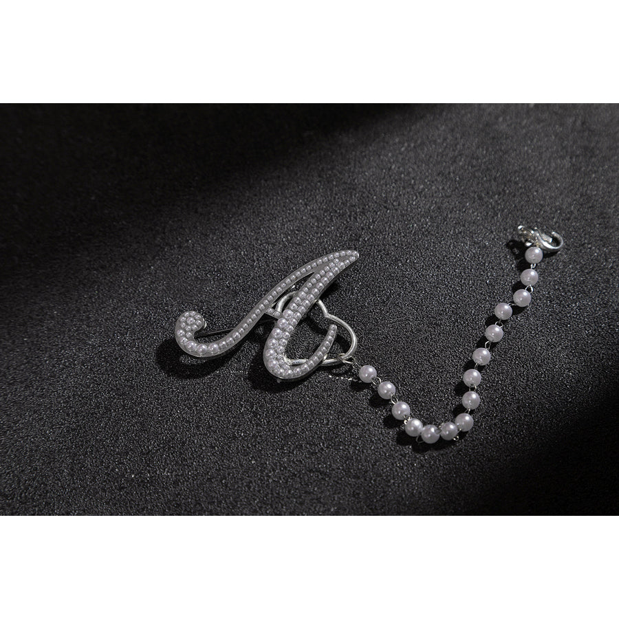 Wuthering Waves Aemeath cosplay arm chain charm detail pairs a silver-tone letter accent with a beaded strand.