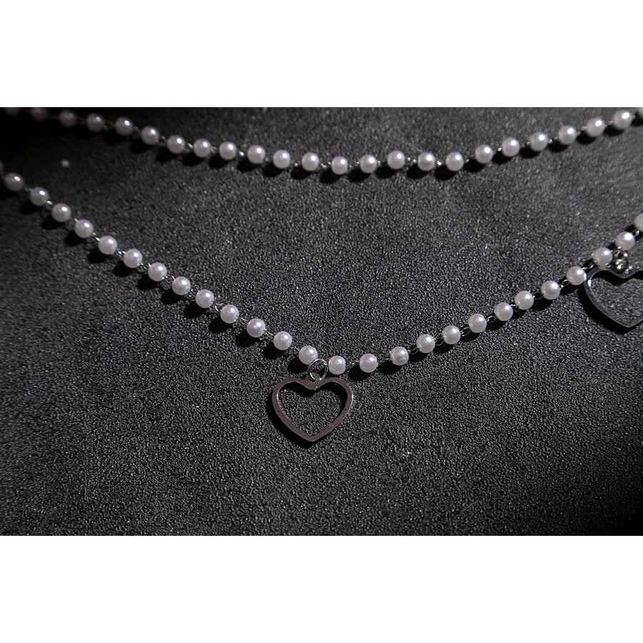 Wuthering Waves Aemeath cosplay waist chain detail drapes pearl-like beads around a small black heart charm.