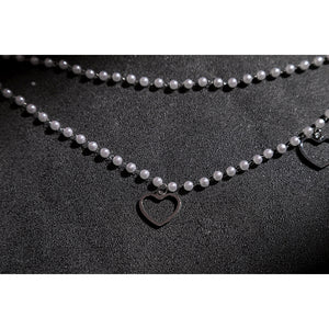 Wuthering Waves Aemeath cosplay waist chain detail drapes pearl-like beads around a small black heart charm.