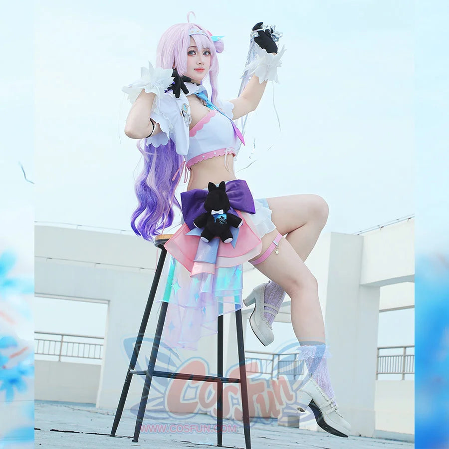 Wuthering Waves Denia cosplay costume seated view sets the white jacket above a side plush, bow, and skirt shorts.