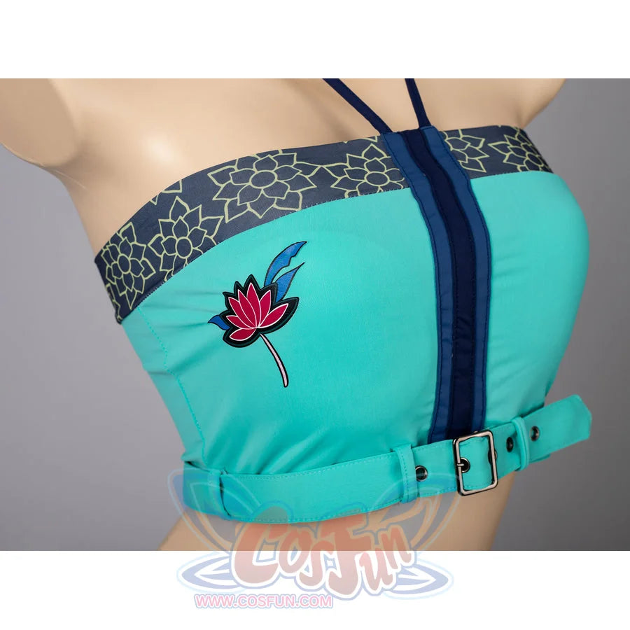 Zoey cosplay tankini top detail centers teal fabric, dark zipper trim, patterned band, and a red flower patch.